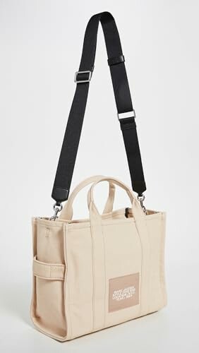 Beige canvas tote bag with black strap.