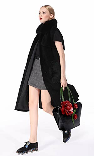Model in black coat and skirt holding a black handbag with red rose
